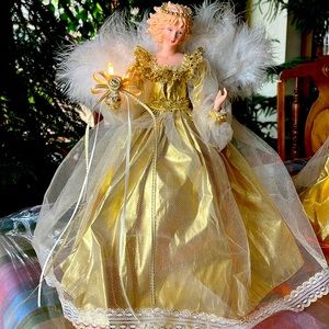 Tree or tabletop 14” plug-in lighted angel dressed in a gold holds a mini light.